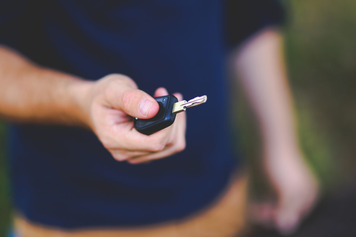 Man in blue shirt holding a car key