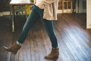 Woman wearing fashionable boots with hands tucked in her jeans pocket