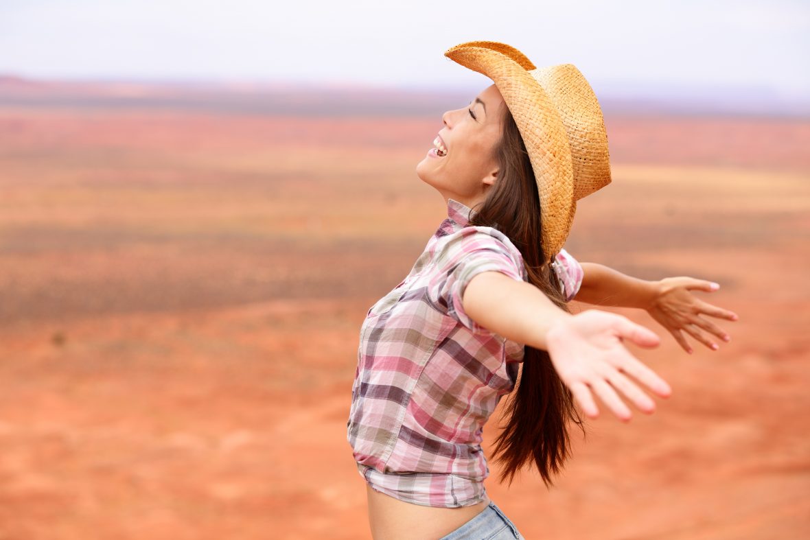 Beautiful cowgirl spreading her arms wide in the Ohio countryside.