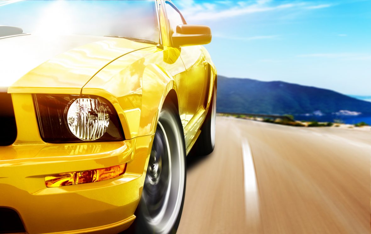 Yellow sports car speeds down an Arizona highway.