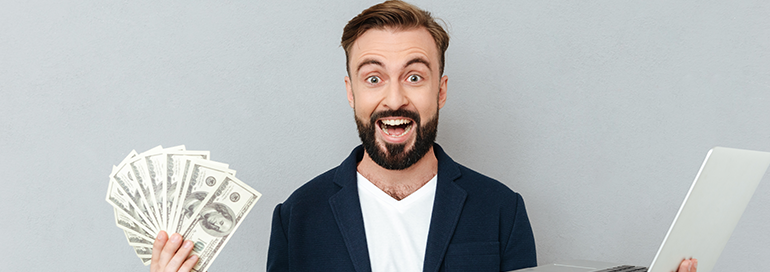 Happy Guy with Lots of Cash In one hand and Laptop in another