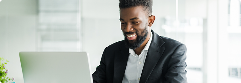 A happy person in formal wear using laptop